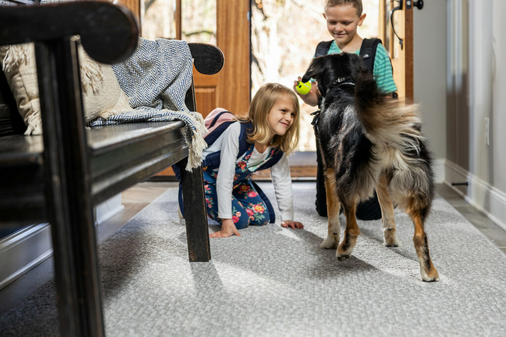 Kids plying with dog on carpet flooring | Family Floors